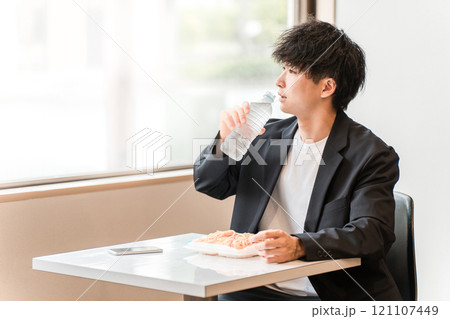 食堂・カフェでランチを食べながら水を飲むビジネスマン・男性 食堂・カフェでランチを食べながら水を飲むビジネスマン・男性 121107449