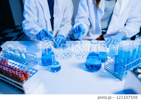 Two Scientist mixing chemical liquids in the chemistry lab. Researcher working in the chemical laboratory Two Scientist mixing chemical liquids in the chemistry lab. Researcher working in the chemical laboratory 121107508