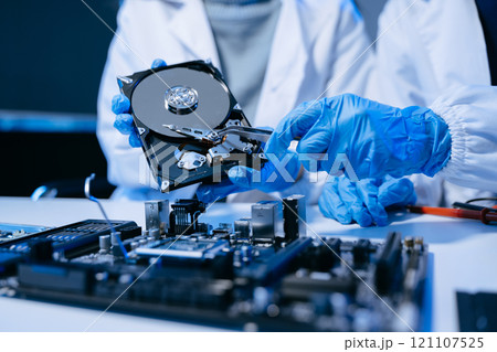 Technician repairing inside of hard disk drive by screwdriver. the concept of data, hardware, technician and technology. computer hardware, upgrade 121107525
