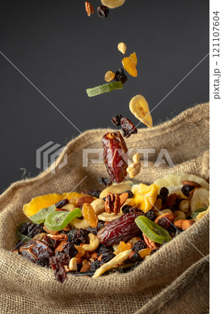 Dried tropical fruits and nuts in burlap bag. Dried tropical fruits and nuts in burlap bag. 121107604