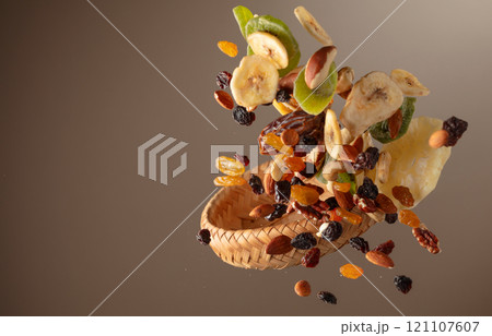 Dried tropical fruits with various nuts and raisins in motion. Dried tropical fruits with various nuts and raisins in motion. 121107607