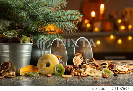 Sweet tropical fruits and Christmas tree on a kitchen table. Sweet tropical fruits and Christmas tree on a kitchen table. 121107608