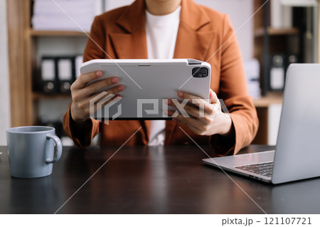 business documents on office table with smart phone and digital tablet and graph financial and woman working 121107721