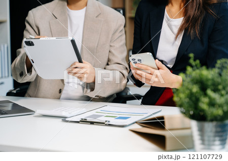 Businessman and team analyzing financial statement Finance task. with smart phone and laptop and  tablet. Wealth management concept 121107729
