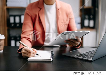 businesswoman hand working with new modern computer and writing on the notepad strategy diagram as concept 121107748