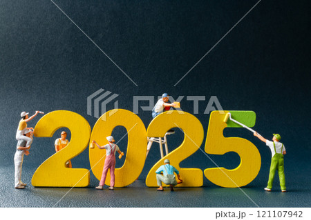 Creative concept of miniature figures painting and constructing the year 2025 121107942