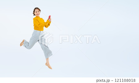 スマホを持ってジャンプする女性の全身写真 121108018
