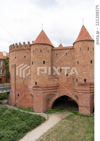 Barbacan castle and its fortification walls and structures. The streets of the old city. The sights of the Polish capital Warsaw. Barbacan castle and its fortification walls and structures. The streets of the old city. The sights of the Polish capital Warsaw. 121108575