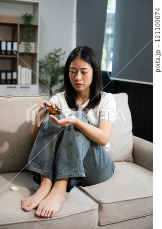 woman sit Depression Dark haired  pensive glance Standing by window on sofa and anxiety 121109074