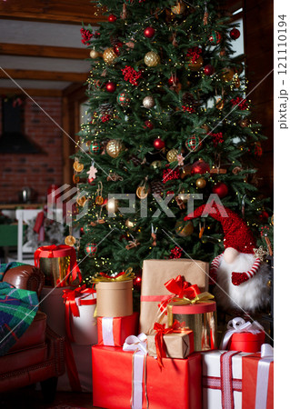 Christmas tree with lights and gifts. Home cozy holiday. The atmosphere of the new year. The garlands are shining. Christmas background 121110194