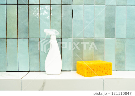 A tiled surface is prepped for repair with epoxy grout, adhesive, a spray bottle, and a sponge. A tiled surface is prepped for repair with epoxy grout, adhesive, a spray bottle, and a sponge. 121110847