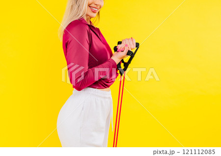 Sports woman in fashion sportswear exercising with elastic band in studio Sports woman in fashion sportswear exercising with elastic band in studio 121112085