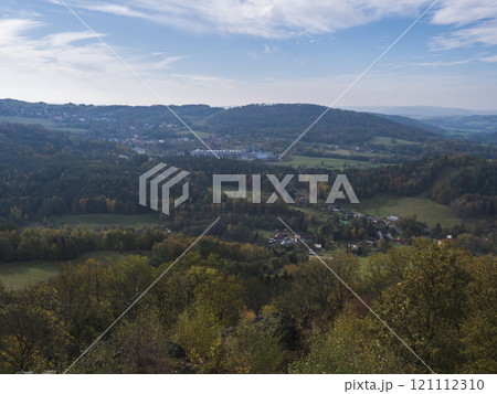 Panoramic view from viewpoint Stredni vrch near Dolni Prysk, Ceska Kamenice. Autumn landscape with colorful forest, hills and blue cloudy sky in Luzicke hory Lusatian Mountains, Czech Republic. 121112310