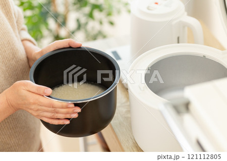 炊飯器でお米を炊くミドル女性の手元 炊飯器でお米を炊くミドル女性の手元 121112805