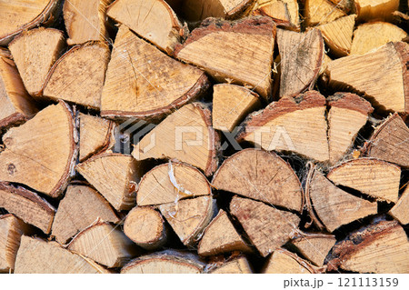 Background. Wood chopped up and stacked into a storage pile. Collecting firewood as a source of energy. Different sizes and shapes of logs after felling, materials for tools and shelter from above. 121113159