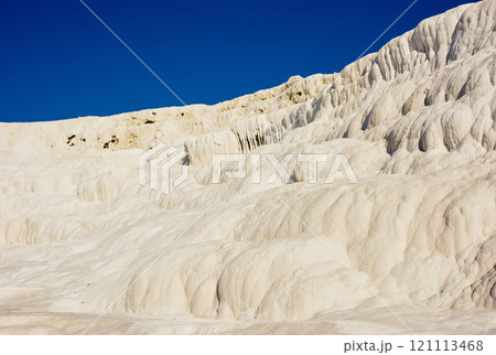 Scenic view of travertine pools and terraces in Pamukkale, Turkey. Traveling abroad, overseas for vacation and tourism. Cotton castle area with a carbonated mineral after flowing thermal spring water Scenic view of travertine pools and terraces in Pamukkale, Turkey. Traveling abroad, overseas for vacation and tourism. Cotton castle area with a carbonated mineral after flowing thermal spring water 121113468