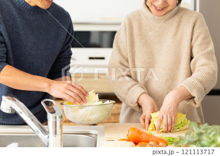 キッチンで鍋料理の準備をするミドル夫婦 121113717