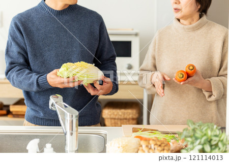 キッチンで鍋料理の準備をするミドル夫婦 121114013