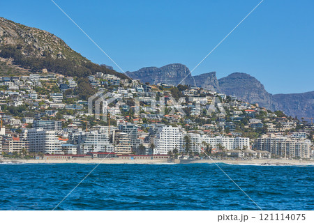 Panorama seascape with clouds, blue sky, and fancy hotel apartment buildings in the background. Sea Point with the Twelve Apostles and Table Mountain National Park in Cape Town, South Africa Panorama seascape with clouds, blue sky, and fancy hotel apartment buildings in the background. Sea Point with the Twelve Apostles and Table Mountain National Park in Cape Town, South Africa 121114075