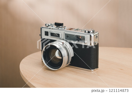 A classic rangefinder film camera sits elegantly. 121114873