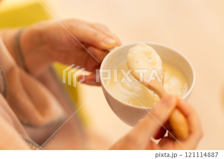 冬の夜のリビングでポタージュスープを食べるミドル女性 121114887