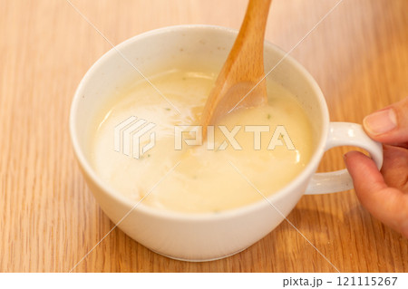 ポタージュスープを飲む女性の手元 121115267