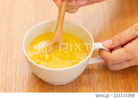 コーンポタージュスープを飲む女性の手元 コーンポタージュスープを飲む女性の手元 121115268