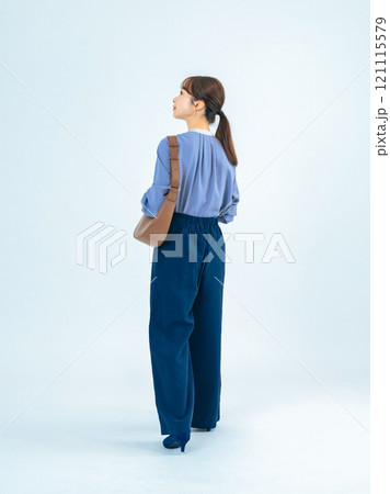 カジュアルウェアを着て歩く女性の後ろ姿の全身写真 カジュアルウェアを着て歩く女性の後ろ姿の全身写真 121115579