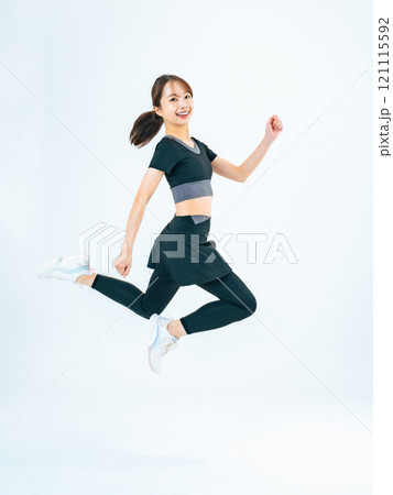スポーツウェアを着てジャンプする女性の全身写真 121115592