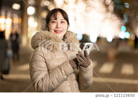 スマホを持ってイルミネーションを見る女性 121115650