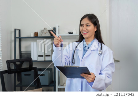 Confident Female Doctor Smiling in Modern Office with Clipboard and Stethoscope, Professional Healthcare Worker in Medical Setting Confident Female Doctor Smiling in Modern Office with Clipboard and Stethoscope, Professional Healthcare Worker in Medical Setting 121117042