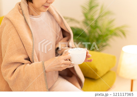 冬の夜のリビングで白湯を飲むミドル女性 冬の夜のリビングで白湯を飲むミドル女性 121117365