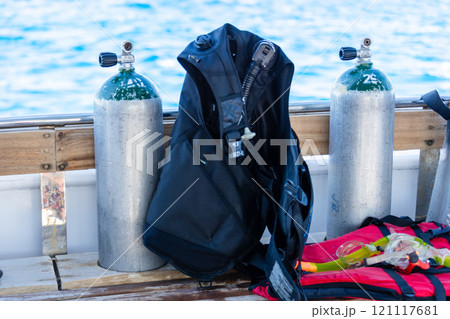 Concept of scuba diving with tank and equipment lying on a boat over blue sea and sunshine Concept of scuba diving with tank and equipment lying on a boat over blue sea and sunshine 121117681