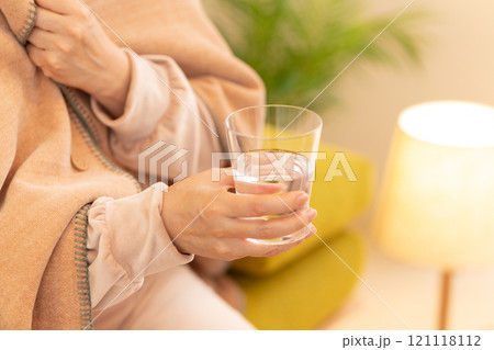 冬の夜のリビングで水を飲むミドル〜シニア女性 121118112