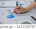 A person is writing on a graph with a pen 121118747