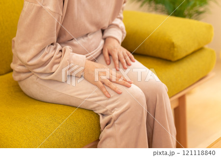 冬の夜のリビングで足の冷えに苦しむミドル〜シニア女性 冬の夜のリビングで足の冷えに苦しむミドル〜シニア女性 121118840