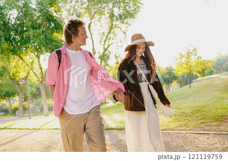 A Couple Enjoyably Strolling Together in the Park While Embracing Natures Wonderful Beauty A Couple Enjoyably Strolling Together in the Park While Embracing Natures Wonderful Beauty 121119759