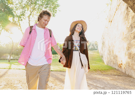 A lovely couple walking hand in hand together in the beautiful embrace of nature A lovely couple walking hand in hand together in the beautiful embrace of nature 121119765
