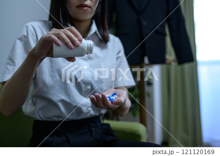オーバードーズ　ODイメージ　大量の薬を接種する女性　薬物過剰摂取　ストレス　鬱病　残業　疲労　過労 121120169