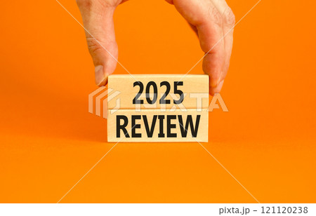 Planning 2025 review new year symbol. Concept words 2025 Review on beautiful wooden blocks. Beautiful orange background. Businessman hand. Business 2025 review new year concept. Copy space. 121120238