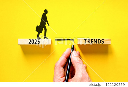 Planning 2025 trends new year symbol. Concept words 2025 Trends on beautiful wooden blocks. Beautiful yellow background. Businessman hand. Business 2025 trends new year concept. Copy space. 121120239