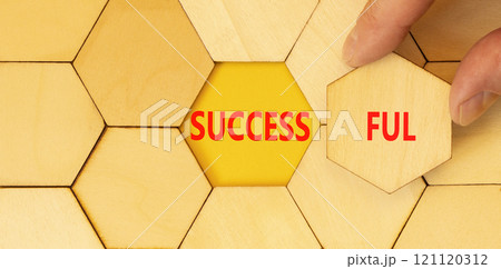Successful symbol. Concept word Successful on beautiful wooden puzzles. Beautiful yellow background. Businessman hand. Business successful concept. Copy space. 121120312