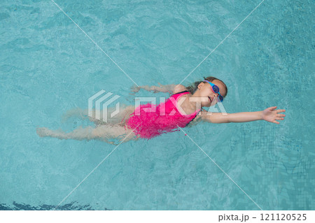 Child practicing backstroke in pool Child practicing backstroke in pool 121120525