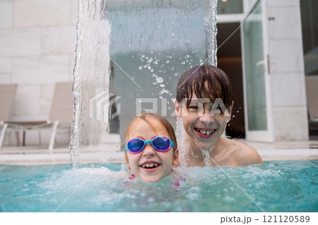 Kids smiling in pool water 121120589