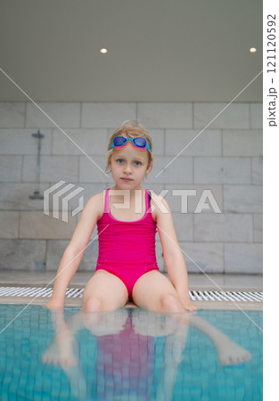 Serious girl wearing swim goggles Serious girl wearing swim goggles 121120592