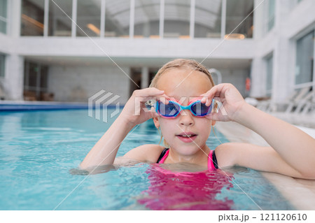 Girl adjusting goggles in pool Girl adjusting goggles in pool 121120610