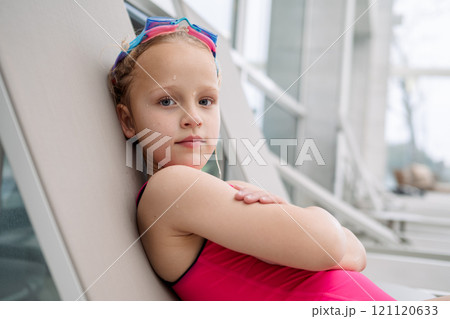 Girl relaxing on poolside lounger Girl relaxing on poolside lounger 121120633