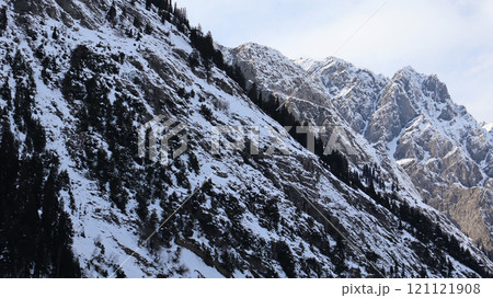 Snow-Capped Mountain Range with Rocky Slopes and Evergreen Trees in Kalam, Pakistan Snow-Capped Mountain Range with Rocky Slopes and Evergreen Trees in Kalam, Pakistan 121121908