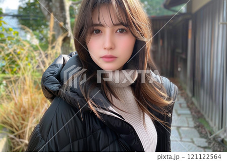 柔らかい表情が魅力的な黒のダウン姿の女性 121122564
