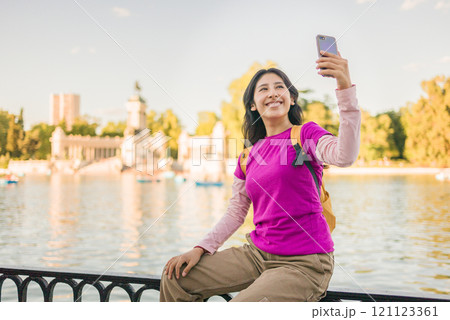Young peruvian woman taking selfie in retiro park, madrid 121123361